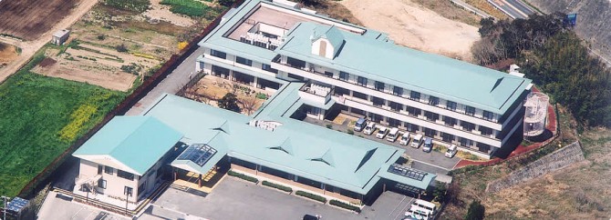 介護施設の上空からの全景。複数棟の建物と周辺環境が見える